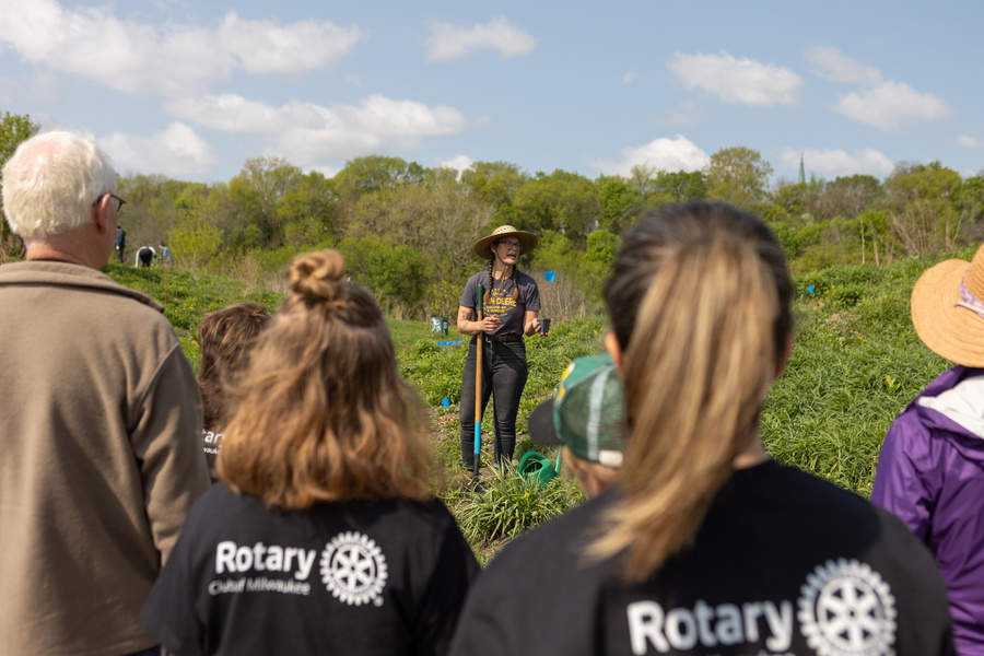 a group of rotary members standing in a field with a person standing in front of them