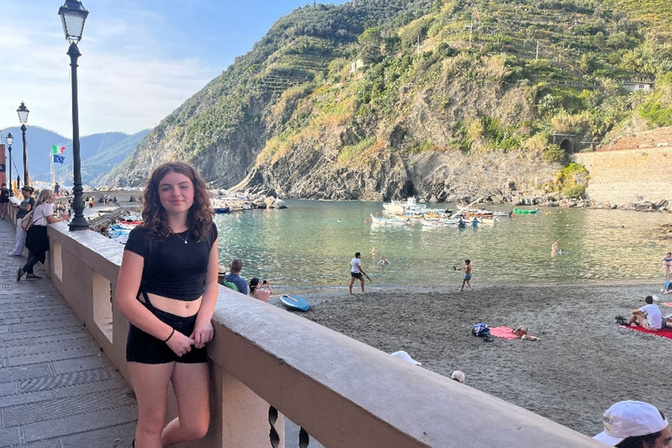 a teenage girls standing on a bridge overlooking the water in Italy