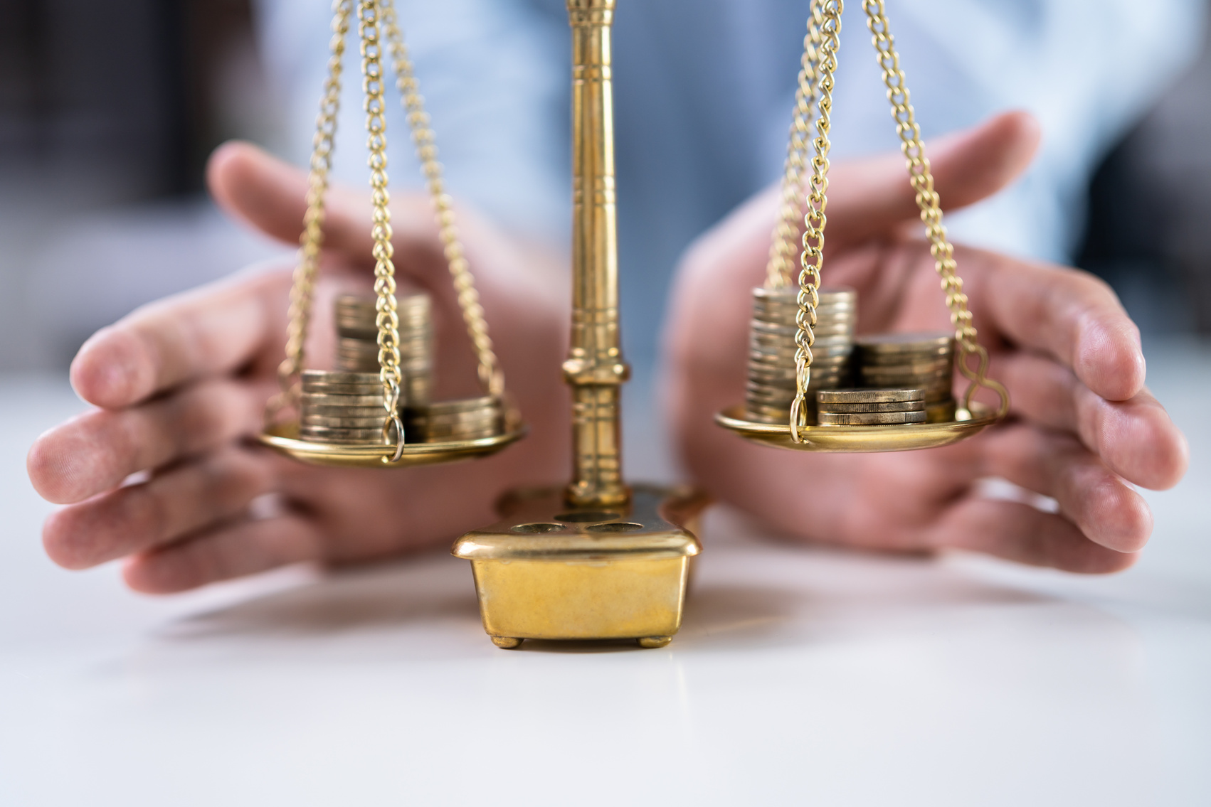 a person holding a balance scale with stacks of coins on it