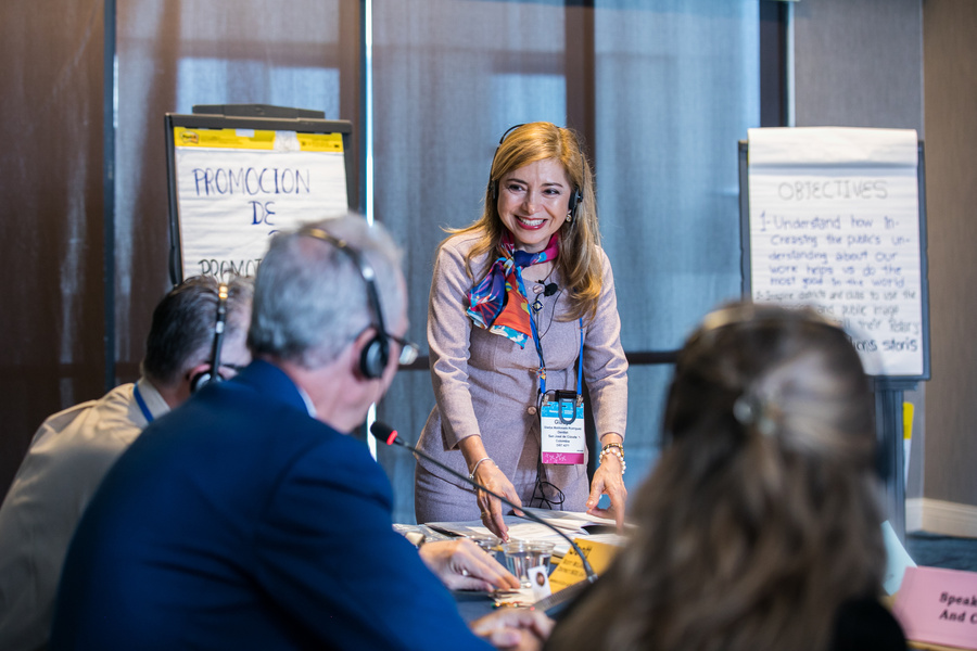 a person is speaking to a group of people at a conference